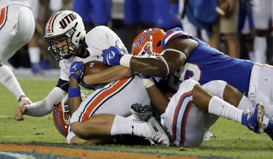 UT Martin quarterback John Bachus III, top left, is sacked by Florida linebacker Lacedrick Brunson, bottom, and defensive lineman Kyree Campbell, right, during the first half of an NCAA college football game Saturday, Sept. 7, 2019, in Gainesville, Fla. (AP Photo/John Raoux)