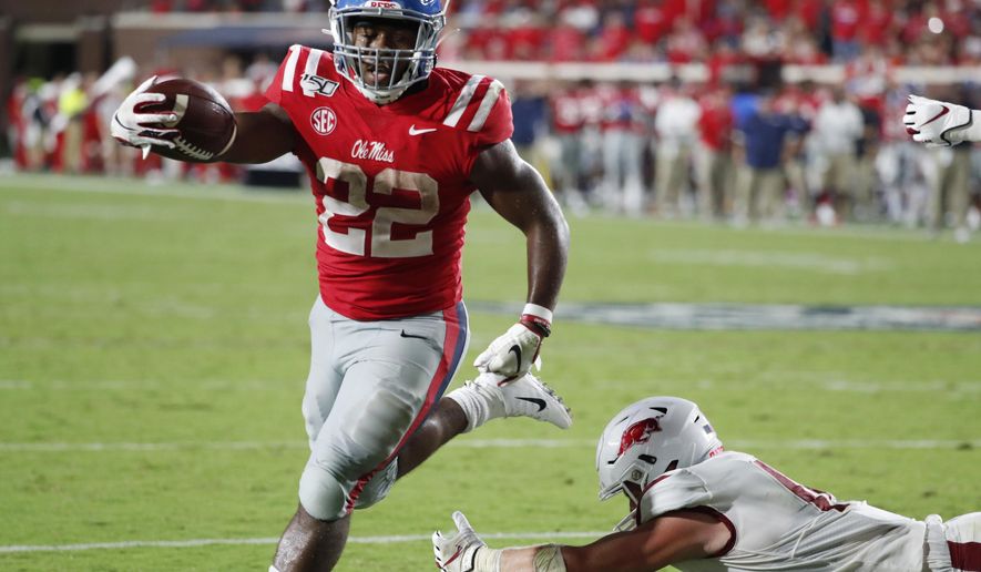 Mississippi running back Scottie Phillips (22) holds out his arm as he scores on a one-yard touchdown run past a fallen Arkansas defender during the second half of their NCAA college football game, Saturday, Sept. 7, 2019, in Oxford, Miss. Mississippi won 31-17. (AP Photo/Rogelio V. Solis)