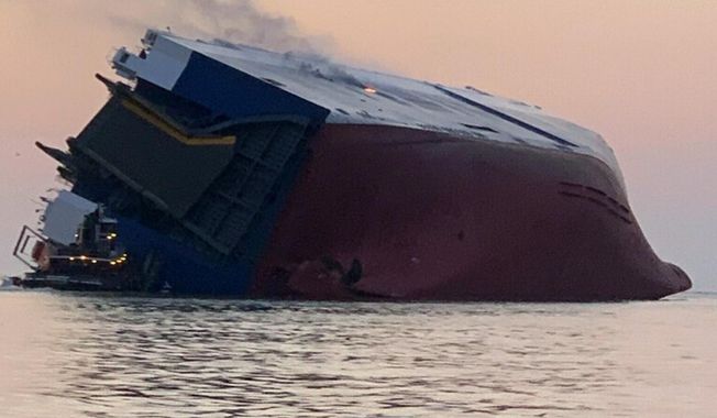 Coast Guard crews and port partners respond to an overturned cargo vessel with a fire on board Sunday, Sept. 8, 2019, in St. Simons Sound, Ga. (U.S. Coast Guard via AP)