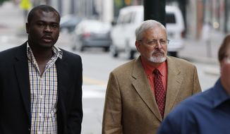 FILE - In this July 9, 2015, file photo, Michael Geilenfeld, right, arrives at U.S. Bankruptcy Court, Thursday, July 9, 2015, in Portland, Maine. An attorney says a defamation lawsuit against a Maine activist who accused an orphanage founder in Haiti of being a serial pedophile has been settled. Paul Kendrick’s attorney told The Associated Press that the defendant’s insurance companies agreed to pay $3 million to Hearts With Haiti but nothing to orphanage founder Michael Geilenfeld. The attorney says Hearts With Haiti and Geilenfeld dropped their defamation claims. (AP Photo/Robert F. Bukaty, File)