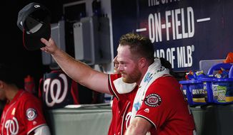 Washington Nationals pitcher Aaron Barrett tips his cap to his teammates after being consoled by them after he pitched his first major league game since 2015, in the fifth inning of a baseball game Saturday, Sept. 7, 2019, in Atlanta. (AP Photo/Tami Chappell) ** FILE **