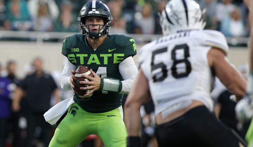 Michigan State quarterback Brian Lewerke, left, looks to pass against Western Michigan's Antonio Balabani (58) during the first quarter of an NCAA college football game, Saturday, Sept. 7, 2019, in East Lansing, Mich. (AP Photo/Al Goldis)