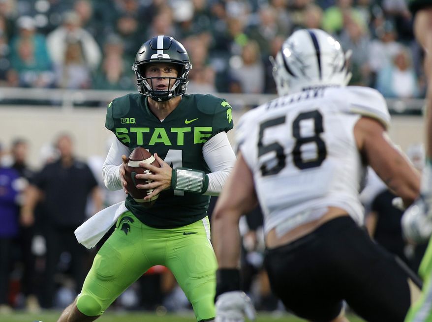 Michigan State quarterback Brian Lewerke, left, looks to pass against Western Michigan's Antonio Balabani (58) during the first quarter of an NCAA college football game, Saturday, Sept. 7, 2019, in East Lansing, Mich. (AP Photo/Al Goldis)