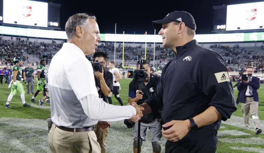 Michigan State coach Mark Dantonio, left, and Western Michigan coach Tim Lester shake hands following an NCAA college football game, Saturday, Sept. 7, 2019, in East Lansing, Mich. Michigan State won 51-17. (AP Photo/Al Goldis)