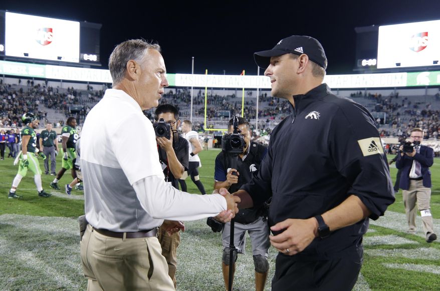 Michigan State coach Mark Dantonio, left, and Western Michigan coach Tim Lester shake hands following an NCAA college football game, Saturday, Sept. 7, 2019, in East Lansing, Mich. Michigan State won 51-17. (AP Photo/Al Goldis)