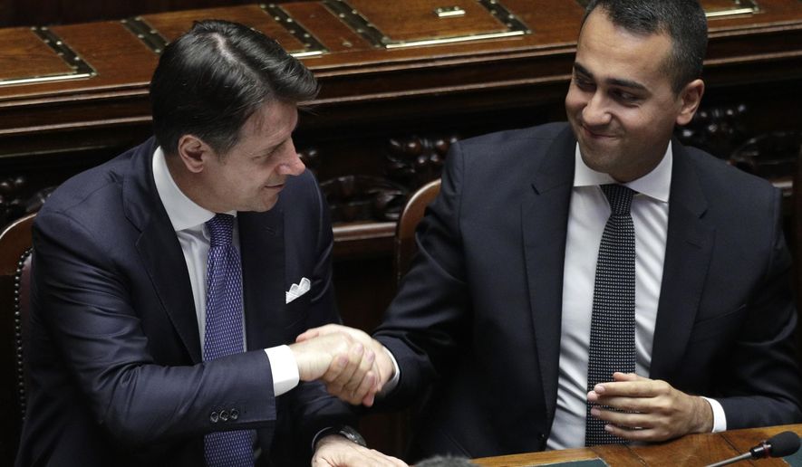 Italian Premier Giuseppe Conte shakes hands with Foreign Minister Luigi Di Maio after addressing parliament ahead of confidence vote later at the Lower Chamber in Rome, Monday, Sept. 9, 2019. The 5-Stars-PD alliance was the unexpected result of Italy's mid-summer crisis, which began when the League's Matteo Salvini, then the powerful interior minister and deputy premier, pulled the plug on the coalition hoping to trigger snap elections and win the premiership.(AP Photo/Andrew Medichini)