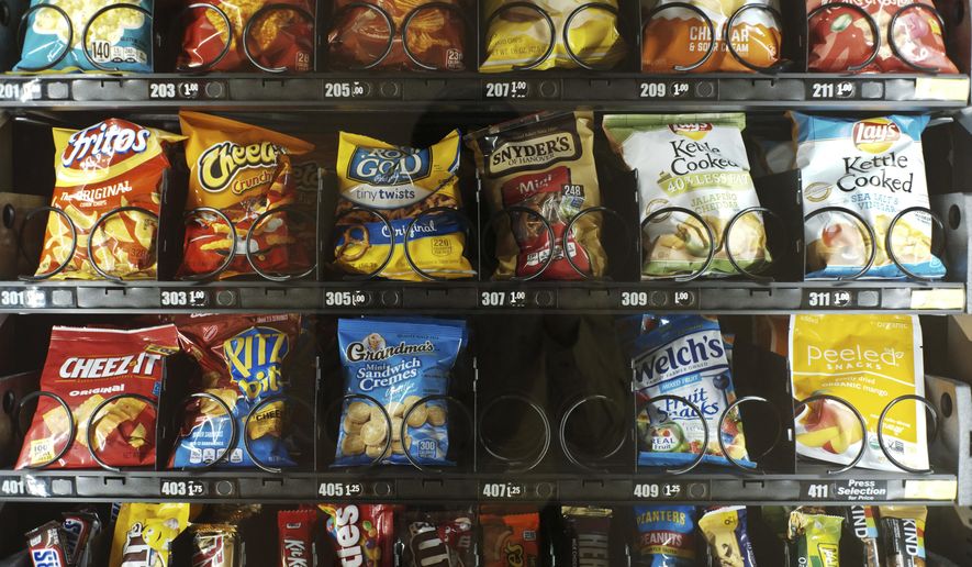 This Saturday, Sept. 7, 2019 photo shows items in a vending machine in New York. Americans are addicted to snacks, and food experts are paying closer attention to what that might mean for health and obesity. (AP Photo/Patrick Sison)
