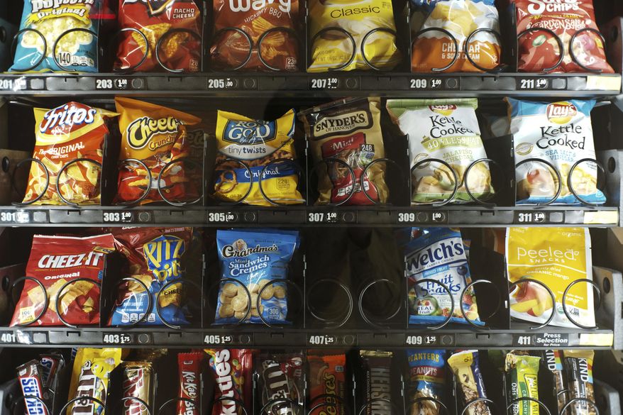 This Saturday, Sept. 7, 2019 photo shows items in a vending machine in New York. Americans are addicted to snacks, and food experts are paying closer attention to what that might mean for health and obesity. (AP Photo/Patrick Sison)