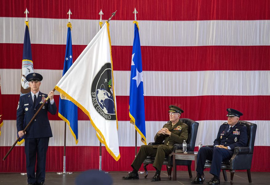 In this file photo from Sept. 9, 2019, Gen. John W. Raymond, U.S. Air Force and commander of the U.S. Space Command, right, and Gen. Joseph F. Dunford, Jr., U.S. Marines and Chairman of the Joint Chiefs of Staff, watch during the presentation of the new U.S. Space Command colors during a ceremony to recognize the establishment of the United States Space Command at Peterson Air Force Base in Colorado Springs, Colo. (Christian Murdock/The Gazette via AP) **FILE**