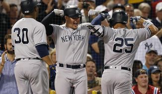 New York Yankees&#39; Gleyber Torres (25) celebrates his two-run home with Luke Voit, center, that also drove in Edwin Encarnacion during the second inning of a baseball game against the Boston Red Sox in Boston, Sunday, Sept. 8, 2019. (AP Photo/Michael Dwyer)