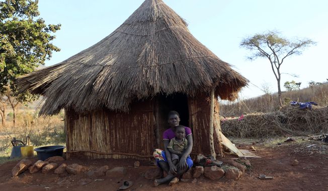 Mary Chipiro, a farm worker at Former Zimbabwean President Robert Mugabe&#x27;s Dairy farm, sits with her child outside her thatched hut at the farm compound in Mazoe, Zimbabwe, Monday, Sept, 9 2019. Mugabe, who enjoyed strong backing from Zimbabwe&#x27;s people after taking over in 1980, but whose support waned following decades of repression, economic mismanagement and allegations of election-rigging, is expected to be buried on Sunday, state media reported. (AP Photo/Tsvangirayi Mukwazhi)