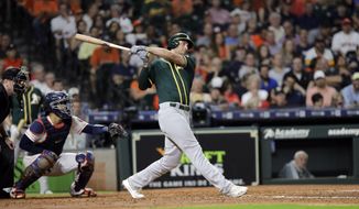 Oakland Athletics&#39; Matt Olson, right, hits a two-run home run as Houston Astros catcher Robinson Chirinos reaches for the pitch during the third inning of a baseball game Tuesday, Sept. 10, 2019, in Houston. (AP Photo/David J. Phillip)