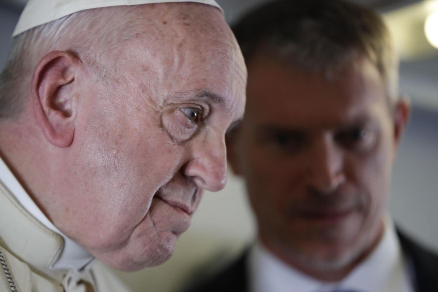 Pope Francis talks with his spokesperson Matteo Bruni, as he addresses journalists during his flight from Antamanarivo to Rome, Tuesday, Sept. 10, 2019, after his seven-day pastoral trip to Mozambique, Madagascar, and Mauritius. (AP Photo/Alessandra Tarantino)