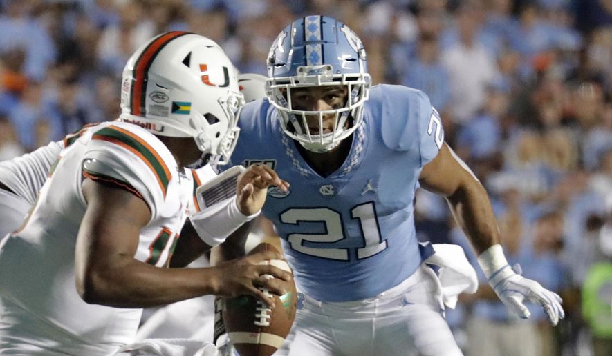 FILE - In this Sept. 7, 2019, file photo, Miami quarterback Jarren Williams (15) is pressured by North Carolina's Chazz Surratt (21) during the first half of an NCAA college football game in Chapel Hill, N.C. The North Carolina-Wake Forest game will put brothers Sage and Chazz Surratt on opposite sides for the first time. Sage is a top receiver for the Demon Deacons, while Chazz has moved from quarterback to linebacker for the Tar Heels -- raising the odds that the two meet in a collision at some point Friday night. (AP Photo/Chris Seward, File)