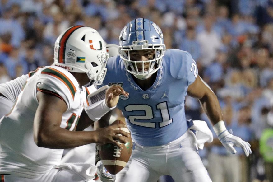 FILE - In this Sept. 7, 2019, file photo, Miami quarterback Jarren Williams (15) is pressured by North Carolina's Chazz Surratt (21) during the first half of an NCAA college football game in Chapel Hill, N.C. The North Carolina-Wake Forest game will put brothers Sage and Chazz Surratt on opposite sides for the first time. Sage is a top receiver for the Demon Deacons, while Chazz has moved from quarterback to linebacker for the Tar Heels -- raising the odds that the two meet in a collision at some point Friday night. (AP Photo/Chris Seward, File)