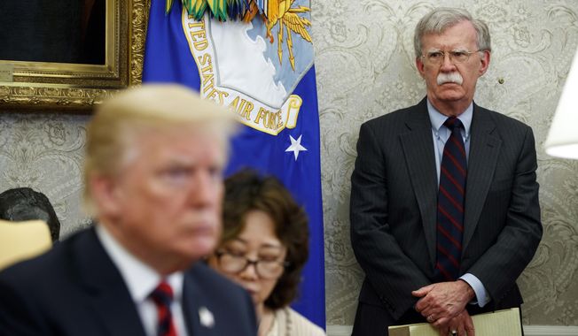 In this May 22, 2018, file photo, U.S. President Donald Trump, left, meets with South Korean President Moon Jae-In in the Oval Office of the White House in Washington, as then-National Security Adviser John Bolton, right, watches. (AP Photo/Evan Vucci, File)