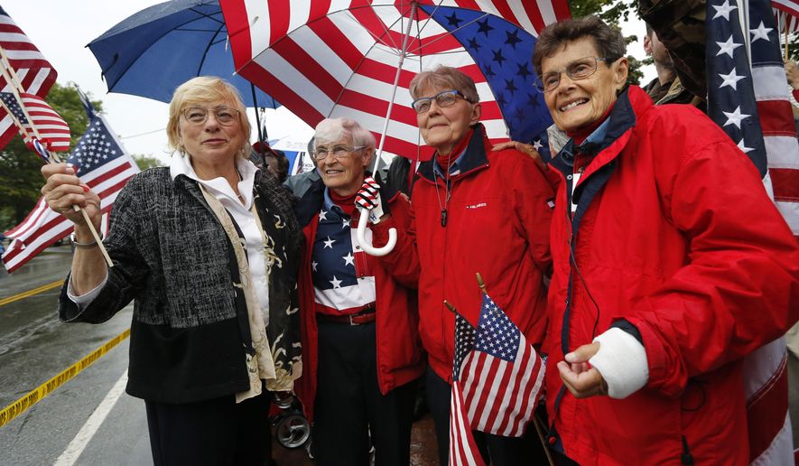 Maine Gov. Janet Mills, far left, shares a moment with the "Freeport flag ladies," left to right, JoAnn Miller, Elaine Greene, and Carmen Footer, on Main Street, Wednesday, Sept. 11, 2019, in Freeport, Maine. The three women who've been waving the Stars and Stripes each week since the 9/11 attacks are retiring the tradition. (AP Photo/Robert F. Bukaty)