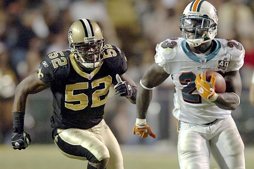 FILE - In this Sunday, Oct. 30, 2005 file photo, running back Ronnie Brown (23) runs against New Orleans Saints linebacker Sedrick Hodge (52) gives chase during the fourth quarter, in Baton Rouge, La. Federal prosecutors said Wednesday, Sept. 11, 2019, that former New Orleans Saint Hodge sold oxycodone pills in Cartersville, Georgia, just northwest of Atlanta. The 40-year-old Hodge is accused of illegal distribution of controlled substances, among other charges.(AP Photo/Bill Feig, File)