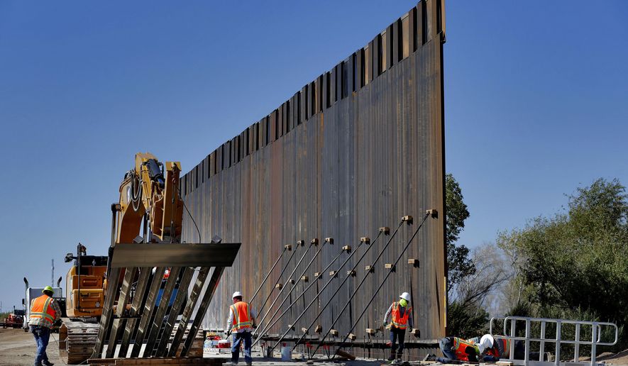 Government contractors erect a section of Pentagon-funded border wall along the Colorado River, Tuesday, Sept. 10, 2019 in Yuma, Ariz. The 30-foot high wall replaces a five-mile section of Normandy barrier and post-n-beam fencing along the the International border that separates Mexico and the United States. Construction began as federal officials revealed a list of Defense Department projects to be cut to pay for President Donald Trump&#39;s wall. (AP Photo/Matt York)