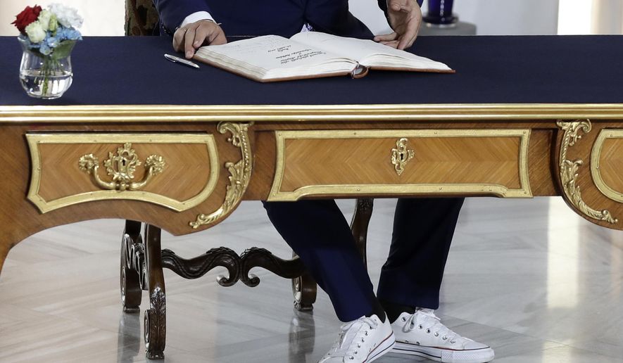 Albanian Prime Minister Edi Rama, wearing sport shoes, signs into a book upon his arrival for the V4+West Balkan summit in Prague, Czech Republic, Thursday, Sept. 12, 2019. (AP Photo/Petr David Josek)