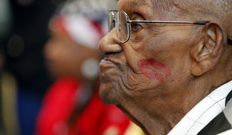 World War II veteran Lawrence Brooks sports a lipstick kiss on his cheek, planted by a member of the singing group Victory Belles, as he celebrates his 110th birthday at the National World War II Museum in New Orleans, Thursday, Sept. 12, 2019. Brooks was born Sept. 12, 1909, and served in the predominantly African-American 91st Engineer Battalion, which was stationed in New Guinea and then the Philippines during World War II. He was a servant to three white officers in his battalion. (AP Photo/Gerald Herbert)