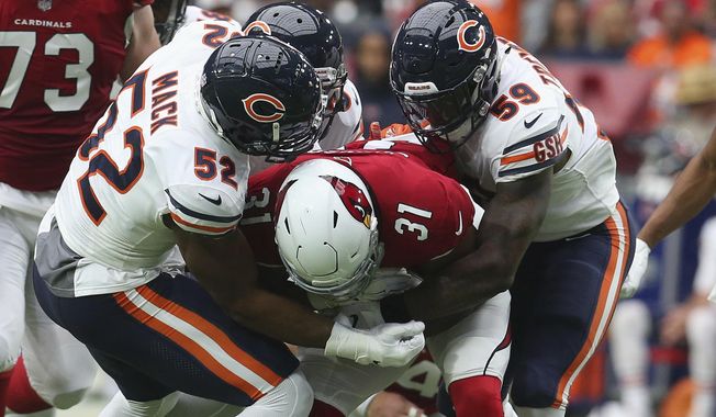 FILE - In  this Sept. 23, 2018, file photo, Chicago Bears linebacker Khalil Mack (52) makes a tackle on Arizona Cardinals running back David Johnson (31) with help from Danny Trevathan (59) during the first half of an NFL football game in Glendale, Ariz. Trevathan returns with the Bears on Sunday, Sept. 15, 2019, to Denver, where he played from 2012-15 and won a Super Bowl. (AP Photo/Ralph Freso, File)