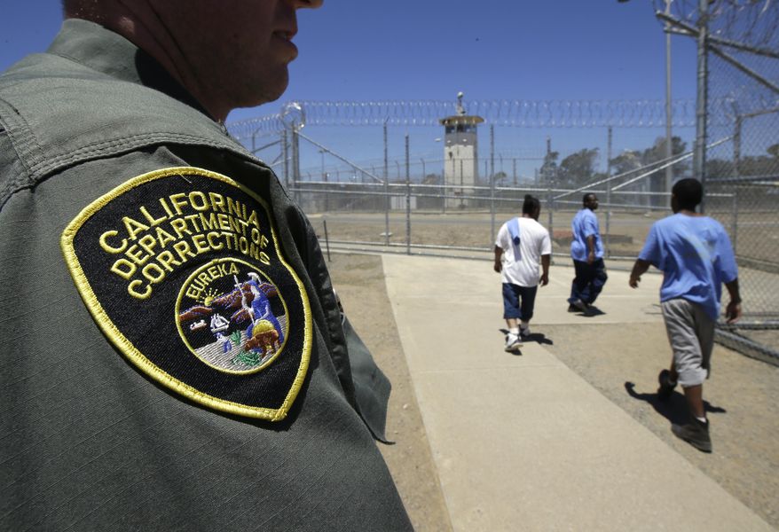 FILE - In this June 20, 2018 file photo, inmates pass a correctional officer as they leave an exercise yard at the California Medical Facility in Vacaville, Calif. The state Assembly approved a bill by state Sen. Scott Wiener, D-San Francisco to trim prison sentences for repeat nonviolent felonies. The bill was sent to the Senate. (AP Photo/Rich Pedroncelli)