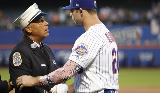 A member of the New York City Fire Department greets New York Mets&#x27; Pete Alonso during a Sept. 11, 2001, tribute before the team&#x27;s baseball game against the Arizona Diamondbacks on Wednesday, Sept. 11, 2019, in New York. (AP Photo/Kathy Willens)