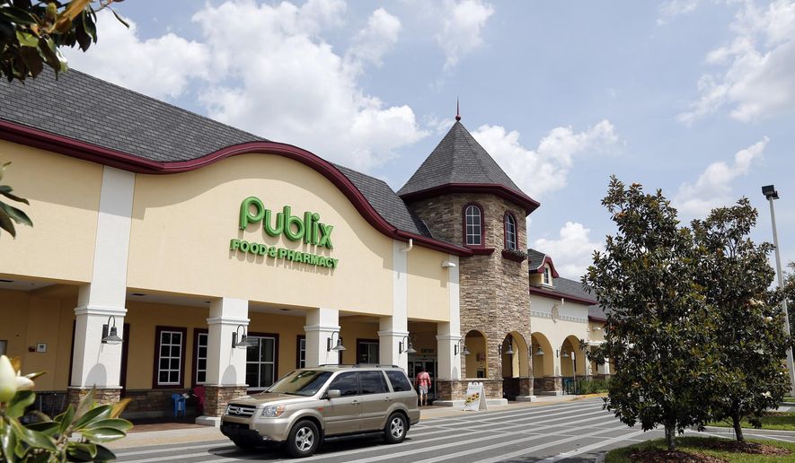 In this Sunday, May 19, 2013, file photo, a vehicle passes the front of the Publix supermarket in Zephyrhills, Fla.  Publix Supermarkets is joining a growing number of retailers in asking customers not to openly carry firearms in its stores, even if state laws allow it. (AP Photo/Scott Iskowitz, File)