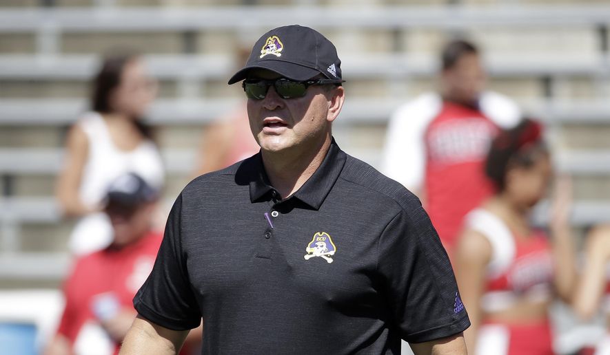FILE - In this Aug. 31, 2019, file photo, East Carolina head coach Mike Houston speaks with players prior to an NCAA college football game against North Carolina State in Raleigh, N.C. First-year East Carolina coach Houston did not need to spend considerable time during the offseason studying film in preparation for the game Saturday, Sept. 14, 2019, against the Midshipmen (1-0). (AP Photo/Gerry Broome, File)