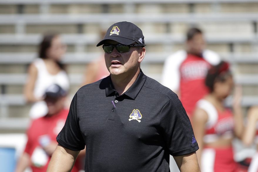 FILE - In this Aug. 31, 2019, file photo, East Carolina head coach Mike Houston speaks with players prior to an NCAA college football game against North Carolina State in Raleigh, N.C. First-year East Carolina coach Houston did not need to spend considerable time during the offseason studying film in preparation for the game Saturday, Sept. 14, 2019, against the Midshipmen (1-0). (AP Photo/Gerry Broome, File)