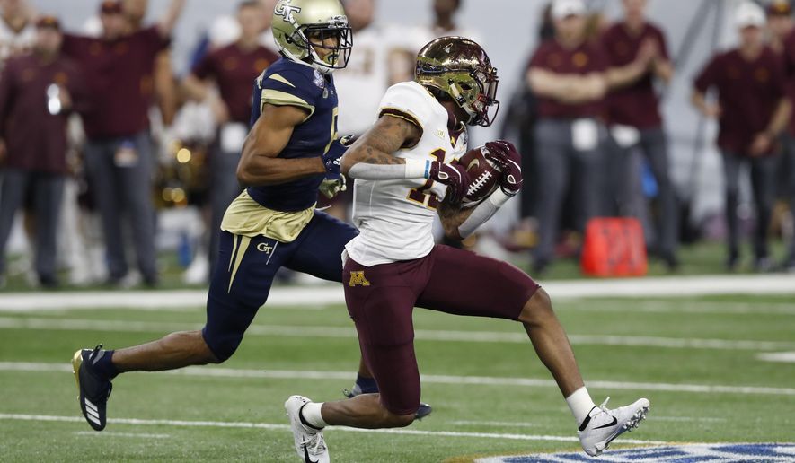 FILE - In this Dec. 26, 2018, file photo, Minnesota wide receiver Rashod Bateman (13) is chased by Georgia Tech defensive back Lamont Simmons during the first half of the Quick Lane Bowl NCAA college football game in Detroit. Tyler Johnson has the most polished credentials for Minnesota, but Bateman has quickly emerged from a deep group of wide receivers as more than just a sidekick. The Gophers play Georgia Southern this week, a school about three hours from Bateman's hometown. (AP Photo/Carlos Osorio, File)