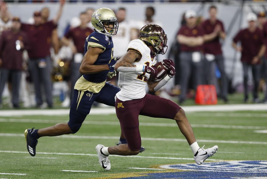 FILE - In this Dec. 26, 2018, file photo, Minnesota wide receiver Rashod Bateman (13) is chased by Georgia Tech defensive back Lamont Simmons during the first half of the Quick Lane Bowl NCAA college football game in Detroit. Tyler Johnson has the most polished credentials for Minnesota, but Bateman has quickly emerged from a deep group of wide receivers as more than just a sidekick. The Gophers play Georgia Southern this week, a school about three hours from Bateman's hometown. (AP Photo/Carlos Osorio, File)