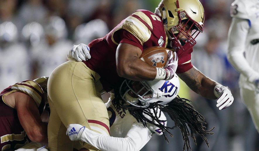 Kansas cornerback Corione Harris, bottom, tackles Boston College running back AJ Dillon during the first half of an NCAA college football game in Boston, Friday, Sept. 13, 2019. (AP Photo/Michael Dwyer)