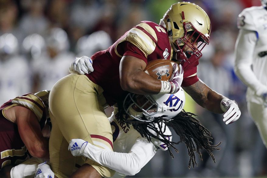 Kansas cornerback Corione Harris, bottom, tackles Boston College running back AJ Dillon during the first half of an NCAA college football game in Boston, Friday, Sept. 13, 2019. (AP Photo/Michael Dwyer)