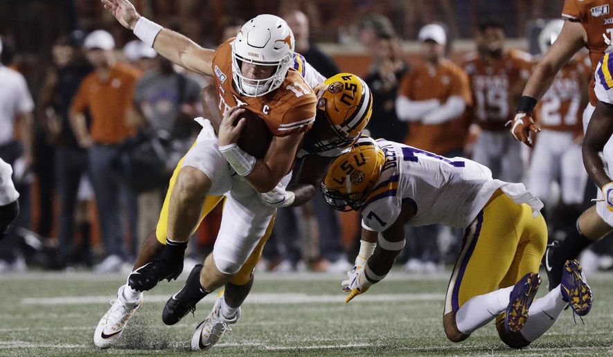 Texas quarterback Sam Ehlinger (11) is hit by LSU defensive end Justin Thomas (93) during the second half of an NCAA college football game Saturday, Sept. 7, 2019, in Austin, Texas. (AP Photo/Eric Gay)