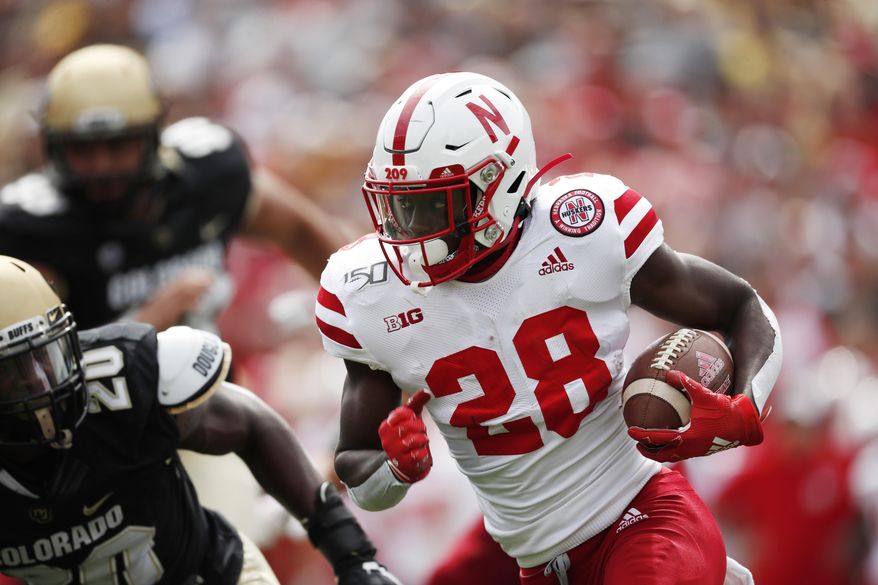 Nebraska running back Maurice Washington (28) drives for a short gain as Colorado linebacker Davion Taylor (20) comes in for the tackle in the first half of an NCAA college football game Saturday, Sept. 7, 2019, in Boulder, Colo. (AP Photo/David Zalubowski)