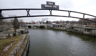 FILE - This Jan. 26, 2016 file photo shows a sign over the Flint River noting Flint, Mich., as Vehicle City. The U.S. Environmental Protection Agency says states are taking action to address the risk of lead in drinking water but more needs to be done to share key information with the public. (AP Photo/Carlos Osorio, File)