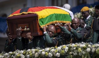 The casket of former president Robert Mugabe is carried by the presidential guard to an air force helicopter for transport to a stadium where it will lie in state, at his official residence in the capital Harare, Zimbabwe Friday, Sept. 13, 2019. The ongoing uncertainty of the burial of Mugabe, who died last week in Singapore at the age of 95, has eclipsed the elaborate plans for Zimbabweans to pay their respects to the former guerrilla leader at several historic sites. (AP Photo/Ben Curtis)
