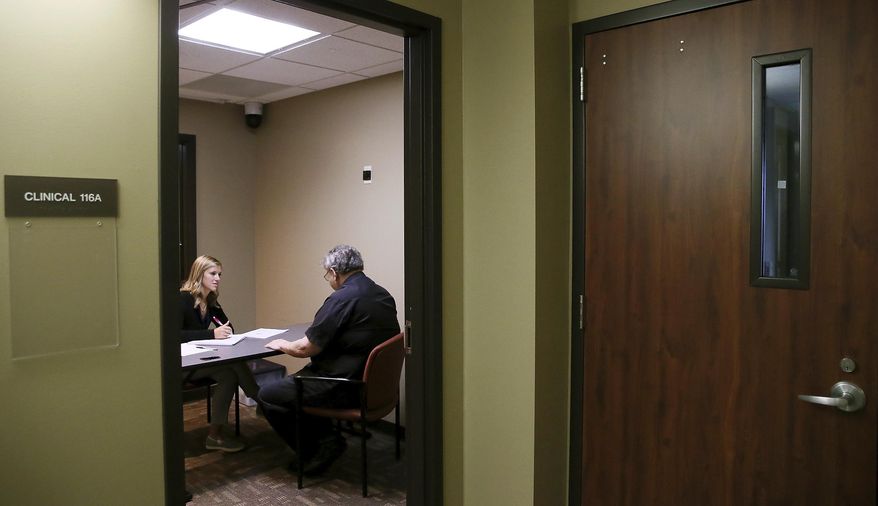 Jessica Stiefer a first-year Speech Language Pathology student at St. Ambrose University's works with Alan Lemming at the Rite Care Clinic in Davenport, Iowa Thursday, on Sept. 5, 2019. In its 10th year, the clinic has treated more than 550 adults and children with speech and language disorders, and helped to train 235 speech-language pathologists. (Kevin E. Schmidt/Quad City Times via AP)