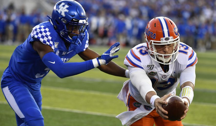Florida quarterback Feleipe Franks (13) reaches for extra yards ahead of Kentucky safety Jordan Griffin (3) during the first half of an NCAA college football game in Lexington, Ky., Saturday, Sept. 14, 2019. (AP Photo/Timothy D. Easley)