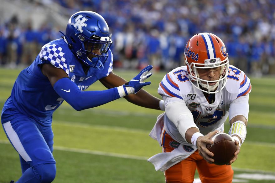 Florida quarterback Feleipe Franks (13) reaches for extra yards ahead of Kentucky safety Jordan Griffin (3) during the first half of an NCAA college football game in Lexington, Ky., Saturday, Sept. 14, 2019. (AP Photo/Timothy D. Easley)