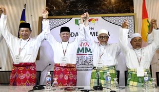 Ahmad Zahid Hamidi, president of UMNO (United Malays National Organisation), center left, and Abdul Hadi Awang, president of PAS (Pan-Malaysian Islamic Party), center right, pose for media after a press conference for an event of officially join alliance in Kuala Lumpur, Malaysia, Saturday, Sept. 14, 2019. Two major opposition parties in Malaysia have forged a political alliance to consolidate support from the country&#39;s majority ethnic Malay Muslims, a move that could threaten Prime Minister Mahathir Mohamad&#39;s government in the next general elections. (AP Photo)