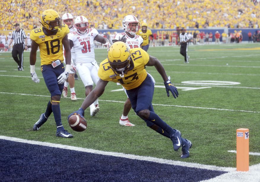 West Virginia wide receiver Sam James (13) scores the Mountaineers' first touchdown during the first half of an NCAA college football game against N.C. State on Saturday, Sept. 14, 2019, in Morgantown, W. Va. (Stephanie Panny/Times-West Virginian via AP)