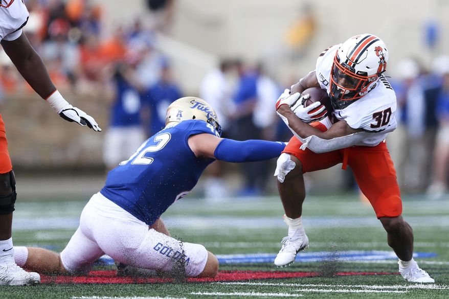 Oklahoma State running back Chuba Hubbard (30) attempts to avoid a tackle by Tulsa linebacker Cooper Edmiston (42) during an NCAA college football game Saturday, Sept. 14, 2019, in Tulsa, Okla. (Ian Maule/Tulsa World via AP)