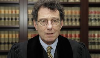 FILE - This Jan. 11, 2018 file photo shows Judge Dan Polster in his office, in Cleveland.  Attorneys representing eight drug distributors, pharmacies and retailers facing trial for their roles in the national opioid crisis are seeking to disqualify the federal judge overseeing their cases saying he’s shown clear bias in his efforts to obtain a multi-billion dollar global settlement. The motion was filed late Friday, Sept. 13, 2019,  in U.S. District Court in Cleveland, where Judge Dan Polster presides over most of the 2,000 lawsuits filed by state, local and tribal governments. Polster has not responded.  (AP Photo/Tony Dejak, File)