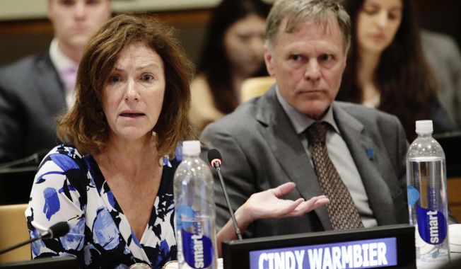 FILE- In this May 3, 2018 file photo, Fred Warmbier, right, listens as his wife Cindy Warmbier, speaks of their son Otto Warmbier, an American who died in 2017 days after his release from captivity in North Korea, during a meeting at the United Nations headquarters.    An administration official said President Donald Trump will host the parents of Otto Warmbier, Saturday, Sept. 14, 2019.   (AP Photo/Frank Franklin II)
