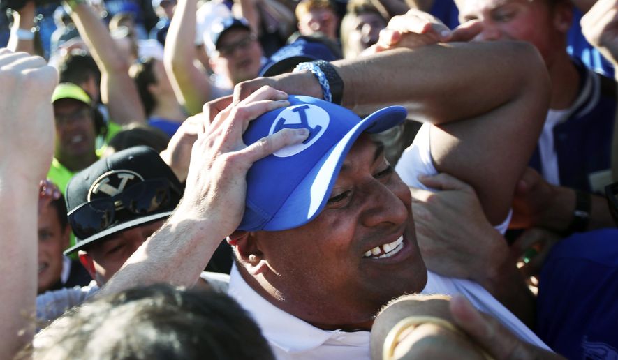 BYU head coach Kalani Sitake celebrates with fans on the field after defeating Southern California on an interception in overtime of an NCAA college football game, Saturday, Sept. 14, 2019, in Provo, Utah. (AP Photo/George Frey)