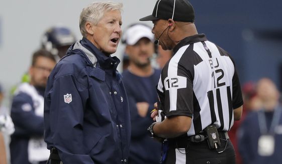 Seattle Seahawks head coach Pete Carroll, left, talks with back judge Greg Steed during the second half of an NFL football game against the Cincinnati Bengals, Sunday, Sept. 8, 2019, in Seattle. (AP Photo/John Froschauer)