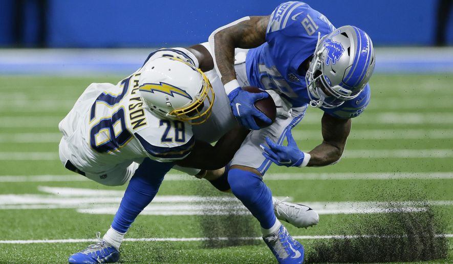 Los Angeles Chargers defensive back Brandon Facyson (28) brings Detroit Lions wide receiver Kenny Golladay (19) down after a reception in the first half of an NFL football game in Detroit, Sunday, Sept. 15, 2019. (AP Photo/Duane Burleson)